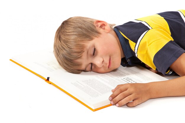 Schoolboy is sleeping on a white background