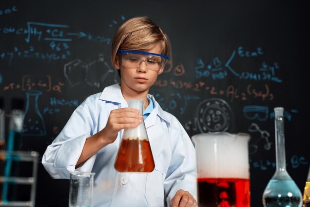 Школьник в лаборатории носит лабораторное пальто изучает науку химии Эрудиция