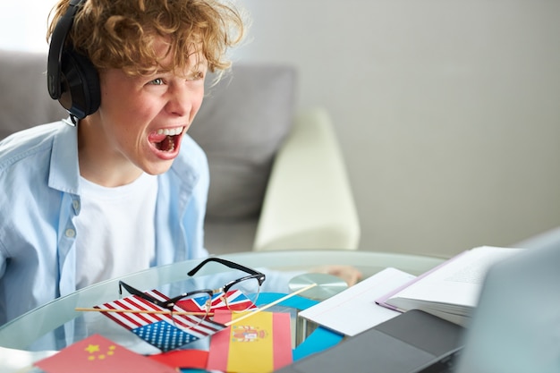 ノートパソコンを見て、ドンの宿題の時間の間にゲームをしている男子生徒の悲鳴