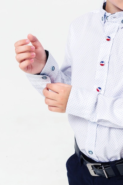 Schoolboy in a shirt on a white background Boy demonstrating shirt cuffs Vertical video