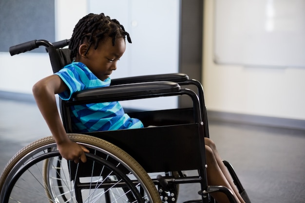 Schoolboy sitting on wheelchair