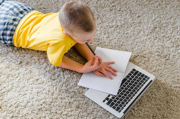 Scolaro che studia a casa con il computer portatile