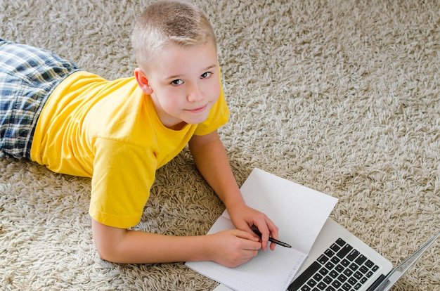 Schoolboy studying at home with laptop
