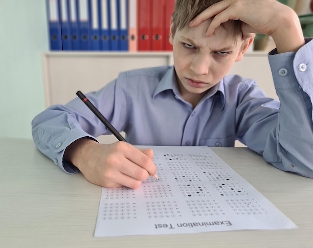 Schoolboy takes a difficult exam at school