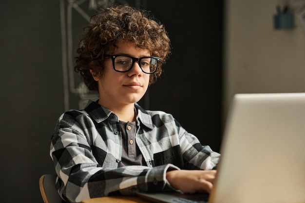 Schoolboy using laptop during lesson