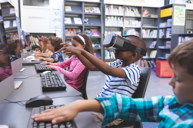 Schoolboy using virtual reality headset in computer room