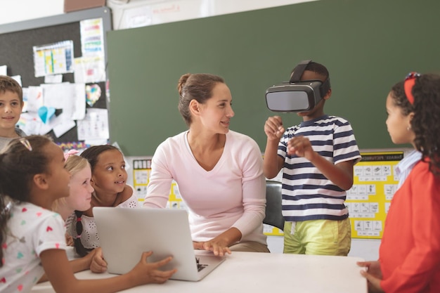 Schoolboy using virtual reality headset at school in classroom