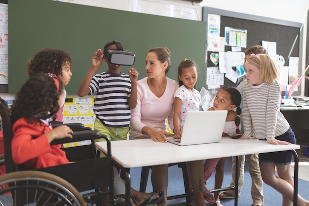 Schoolboy using virtual reality headset at school in classroom