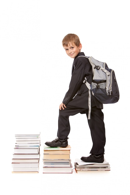 Schoolboy with a bagpack and books isolated