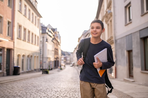 Schoolboy with the book on a city street