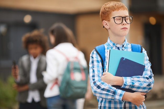 Schoolboy with books outdoors