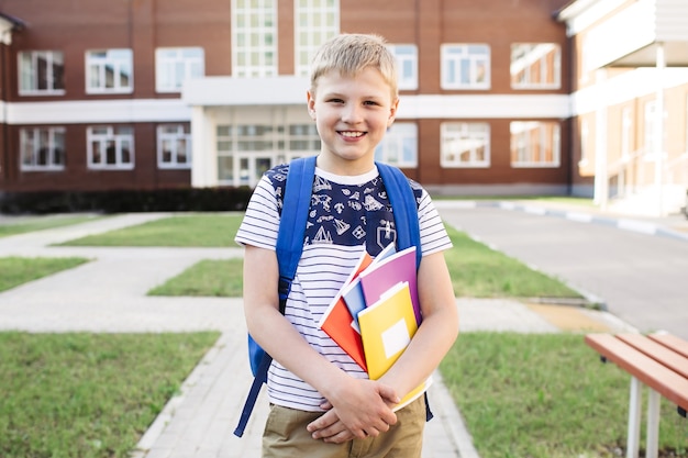 Schoolboy with notebooks and backpack