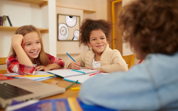 Photo schoolchildren preparing lessons together and discussing the tasks