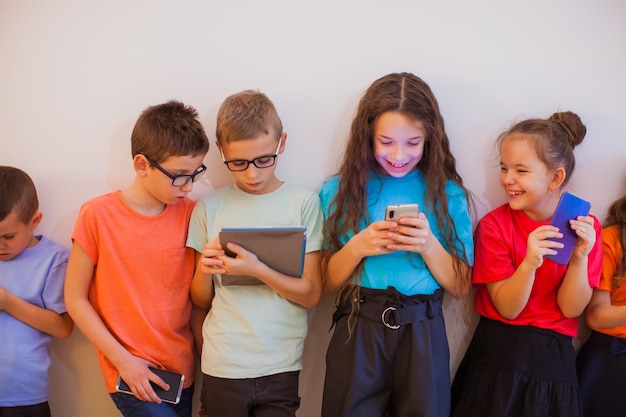 Schoolchildren with gadgets watching online live broadcasting