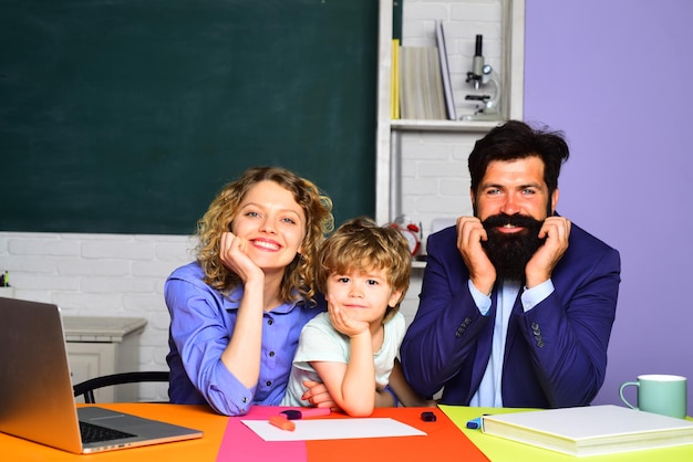 Schoolconcept gelukkige familie vrouw en man helpt de kindjongen voor het eerst naar school jong gelukkig