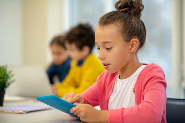 Schoolgirl being serious looking at the tablet screen