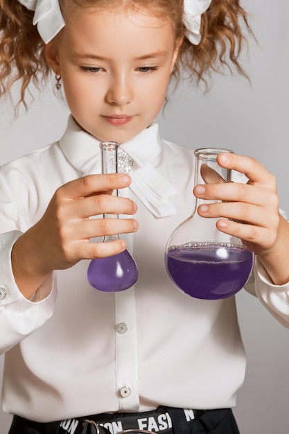 A schoolgirl compares liquids in flasks after a chemical experiment Studying chemistry