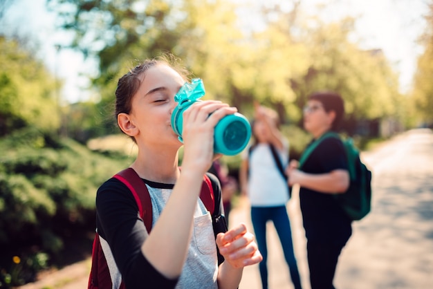 Школьница питьевой воды на школьном дворе