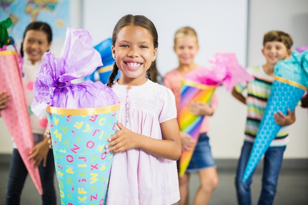 Schoolgirl holding gift in classroom