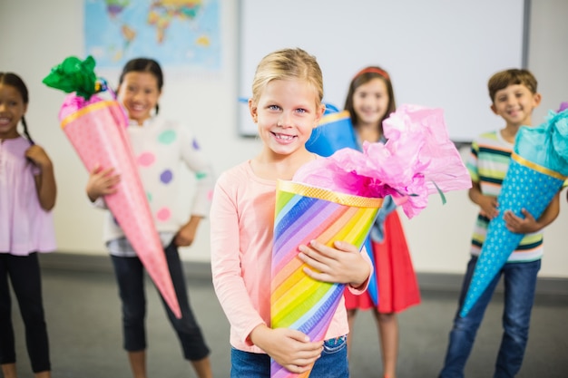 Schoolgirl holding gift in classroom