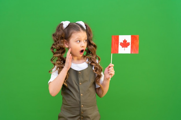 A schoolgirl holds a Canadian flag and smiles Studying at a Canadian school and getting an education