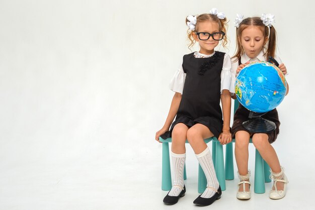 schoolgirl isolated on white with globe little girl in school uniform