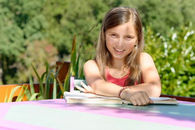 Schoolgirl learns his lessons on the garden table