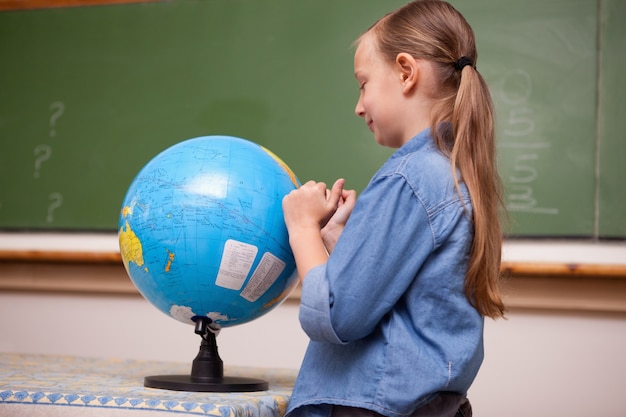 Schoolgirl looking at a globe