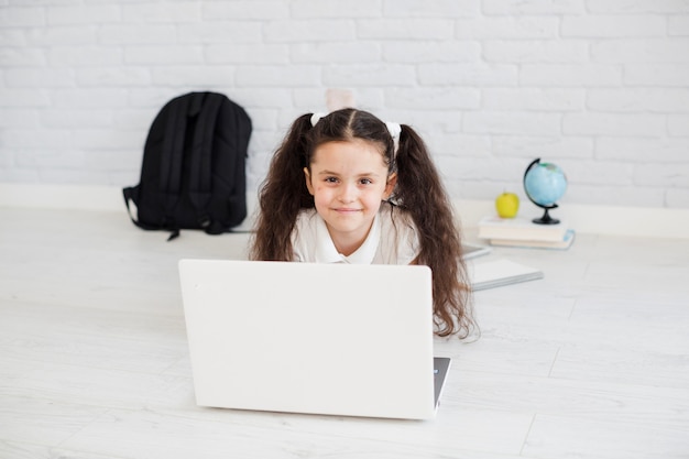 Schoolgirl lying at laptop