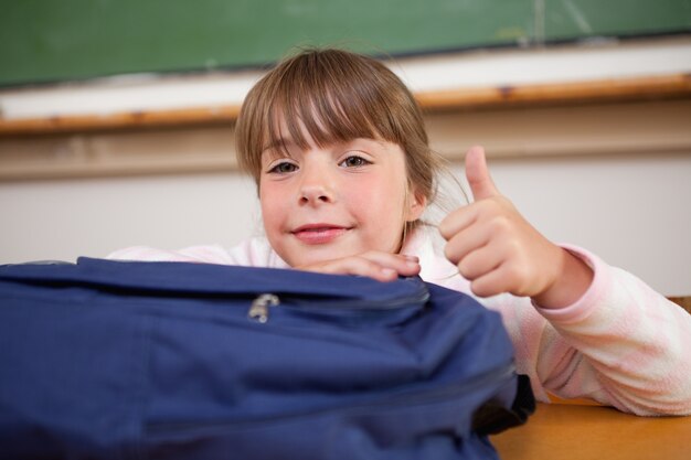 Schoolgirl posing with a bag and the thumb up