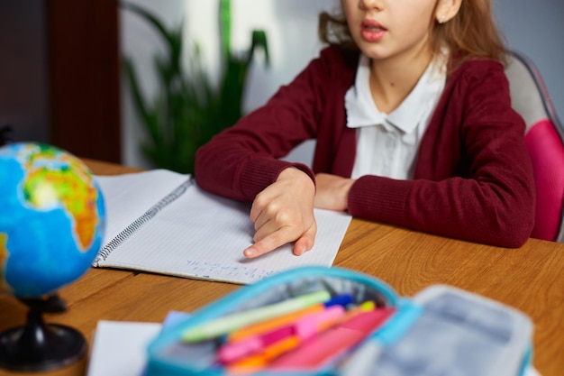 Schoolgirl sit at desk doing homework reading homeschooling