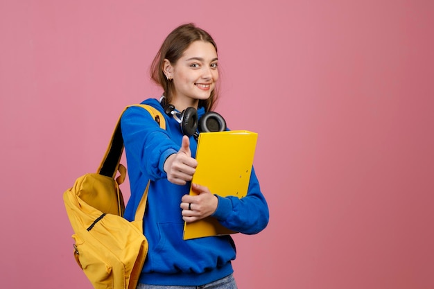 Schoolgirl standing looking at camera smiling