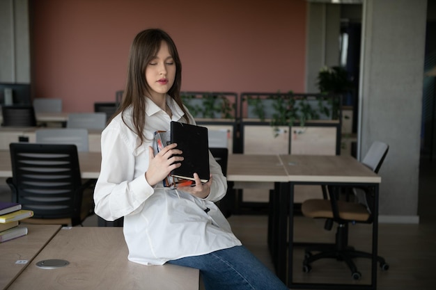 Photo schoolgirl standing with books and backpack at school