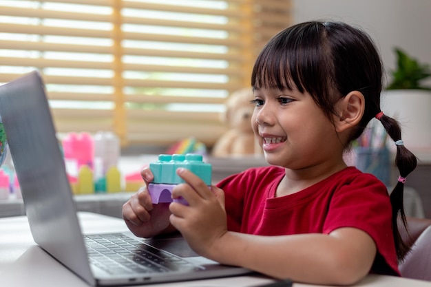 Schoolgirl studying homework math during her online lesson at home social distance during quarantine