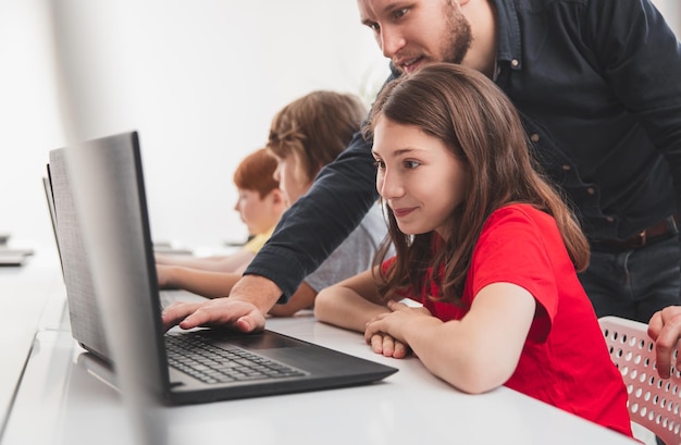 Schoolgirl and teacher during computer class