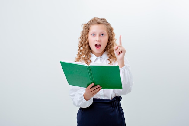 Schoolgirl teenage girl in school uniform holding a book on a white background