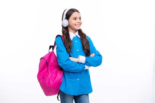 Schoolgirl teenage student girl in headphones on white isolated studio background School and music education concept Back to school