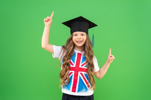 英語の旗をイメージしたTシャツを着た女子高生が広告を指さし、外国語の外国語翻訳で教育を受けて微笑む