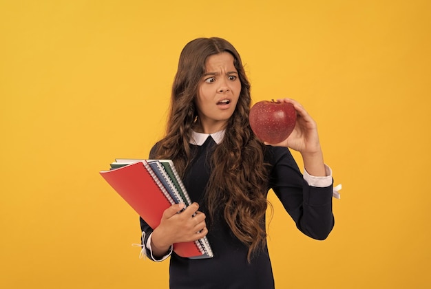 アップルランチを持った女子高生が学校に戻って健康な子供時代を勉強した後、10代の女の子がアップルを食べる