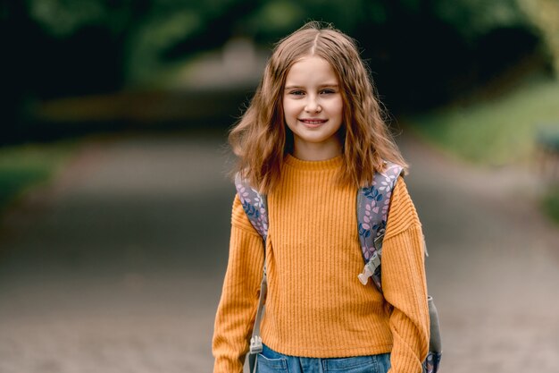 Schoolgirl with backpack outdoors