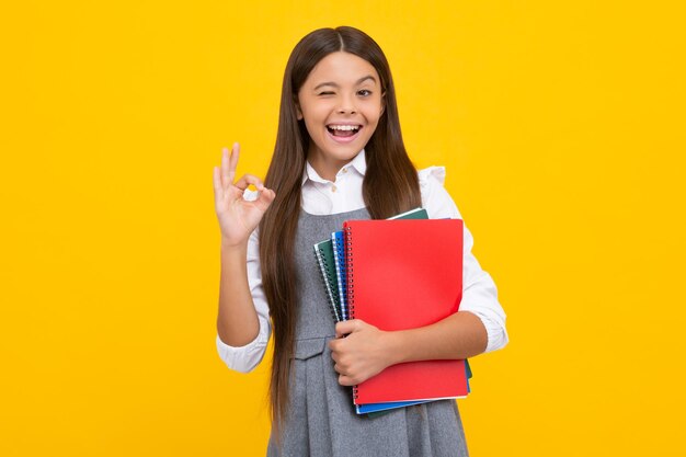 Schoolgirl with copy book posing on isolated background Literature lesson grammar school Intellectual child reader Funny face