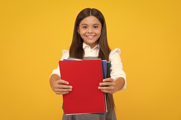 Schoolgirl with copy book posing on isolated background literature lesson grammar school intellectual child reader happy girl face positive and smiling emotions