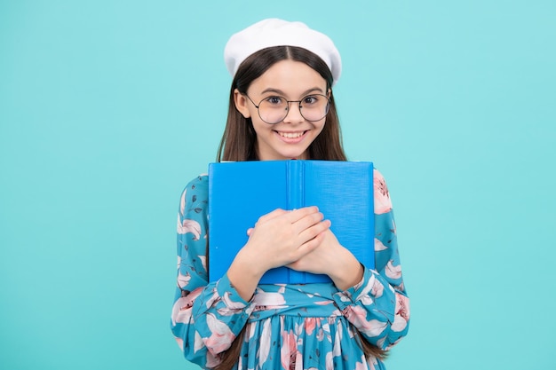 Schoolgirl with copy book posing on isolated background Literature lesson grammar school Intellectual child reader Happy teenager positive and smiling emotions