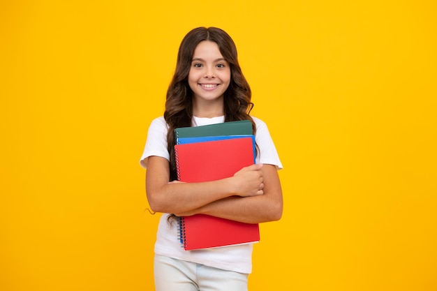 孤立した背景にポーズをとるコピーブックを持つ女子高生文学レッスングラマースクール知的児童リーダー