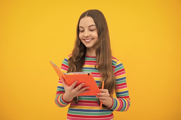 Schoolgirl with copy book posing on isolated background literature lesson grammar school intellectual child reader