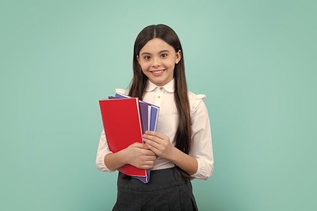 Schoolgirl with copy book posing on isolated background Literature lesson grammar school Intellectual child reader