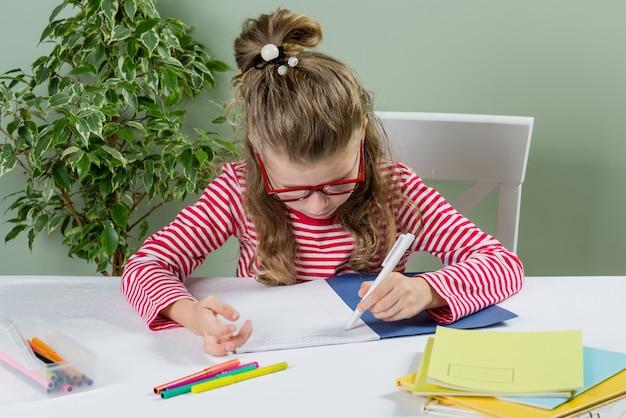 Schoolgirl with glasses writes something