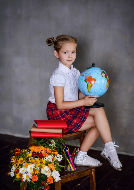 Фото Школьница с земным шаром. концепция школы