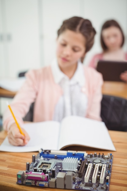 Schoolgirl working on electronic project in classroom