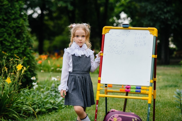 A schoolgirl writes lessons on a whiteboard